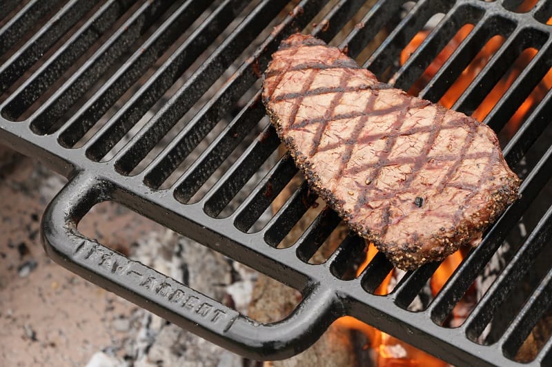 cuisson d'un steak sur un foyer extérieur